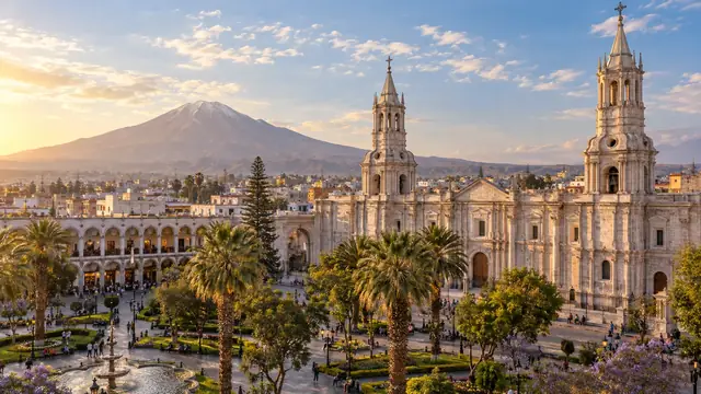 La cathédrale blanche d’Arequipa et ses deux clochers au bord de la Plaza de Armas plantée de palmiers, le volcan Misti à l’horizon