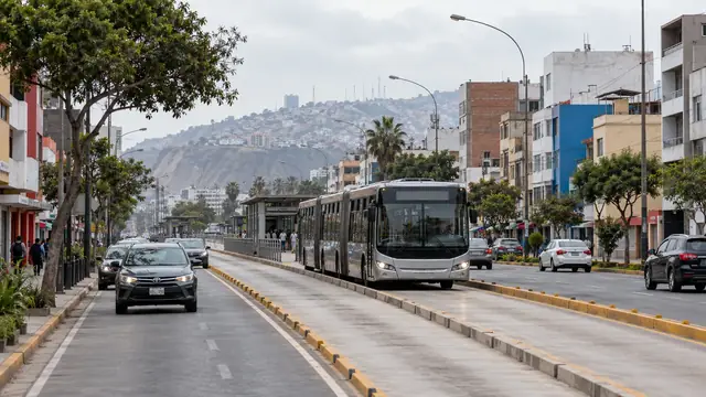Bus articulé sur une voie réservée au centre d’une avenue, voitures sur les voies latérales et colline en arrière-plan