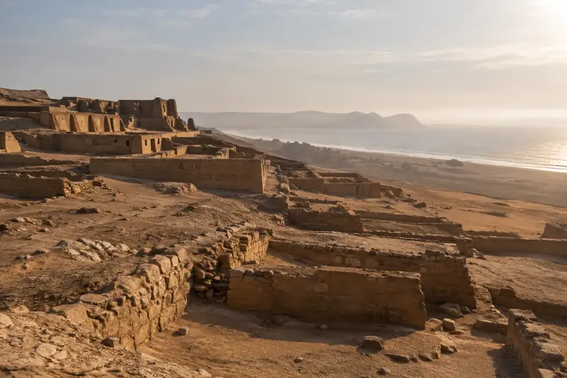 Ruines de murs en terre sur une colline désertique qui domine la mer